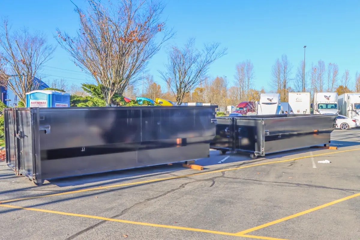 Professional dumpster rental service with roll-off container on residential driveway in Spirit Lake